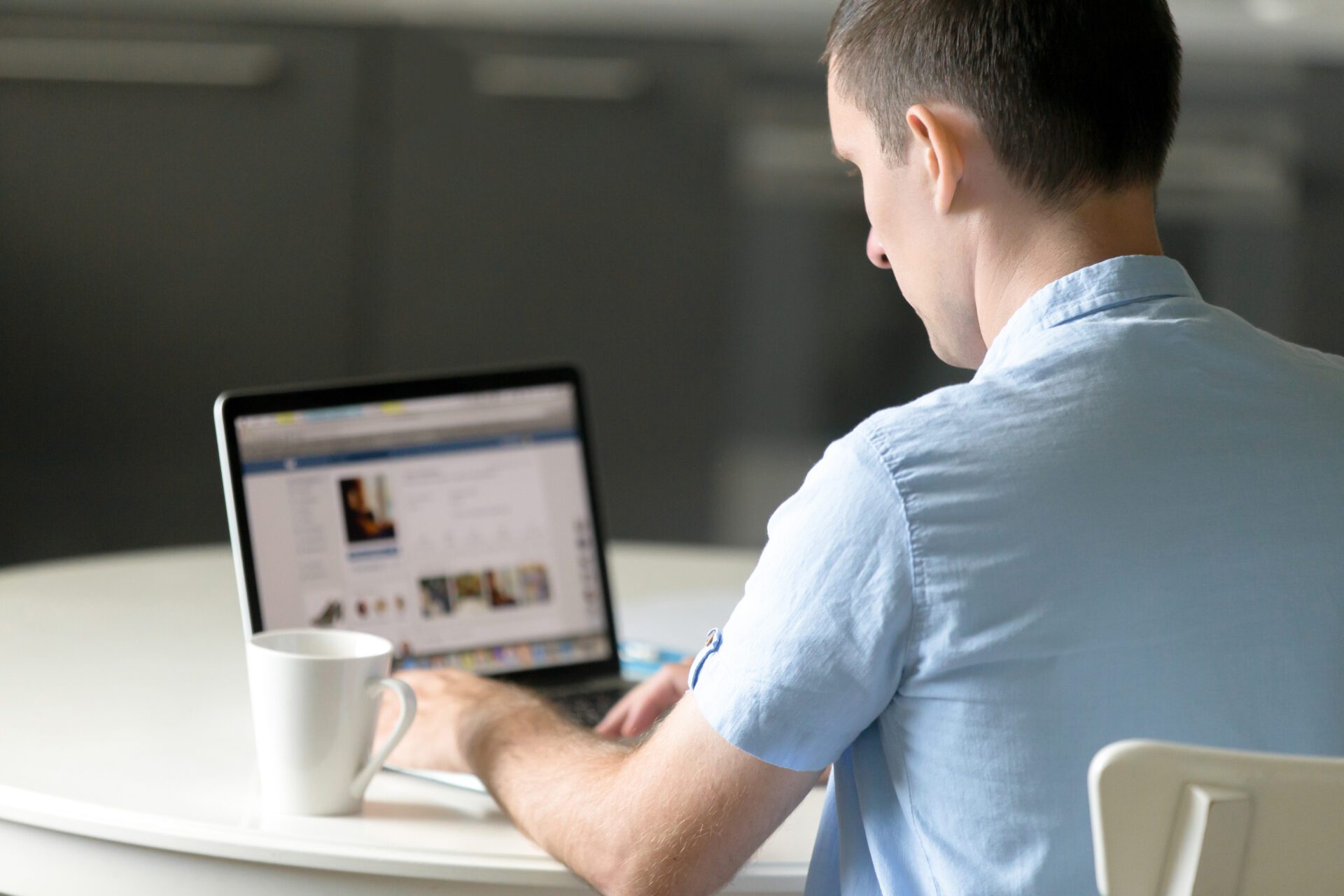 Portrait of a young man working at desk with laptop